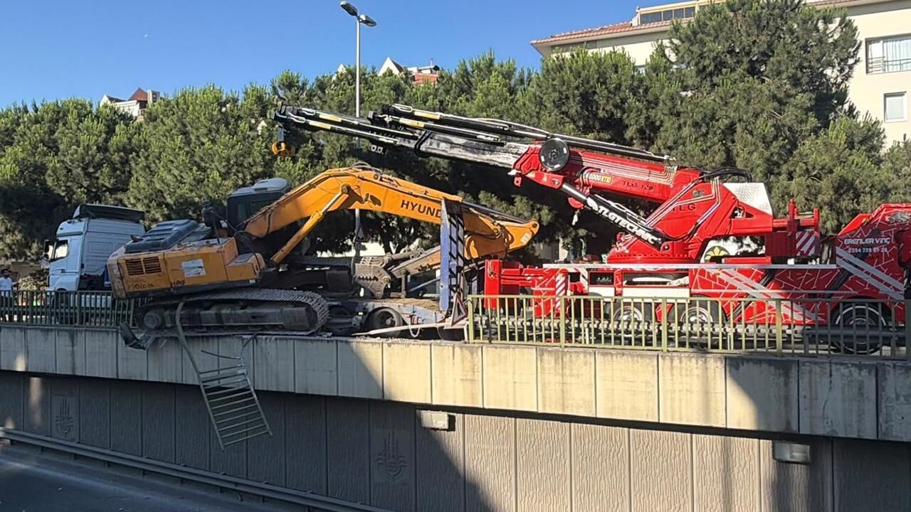 Tırın üzerinden düşen ekskavatör korkuluklarda asılı kaldı