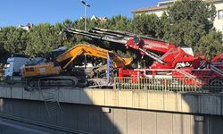 Tırın üzerinden düşen ekskavatör korkuluklarda asılı kaldı